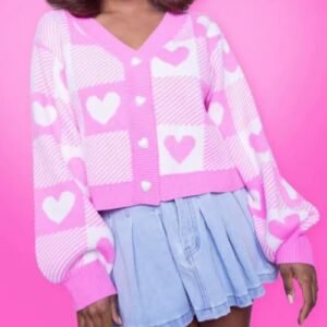 woman wearing Valentine's Cardigan and jeans skirt, pink background