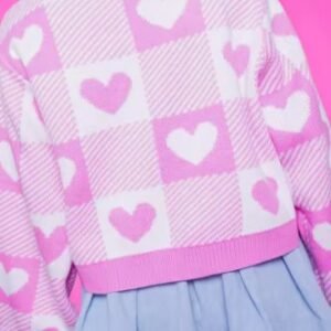 woman turned to her back wearing Valentine's cardigan and jeans mini skirt, pink background