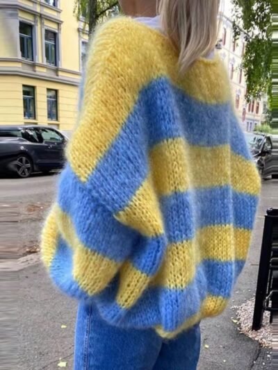 woman wearing blue and yellow colorful sweater, the street behind her