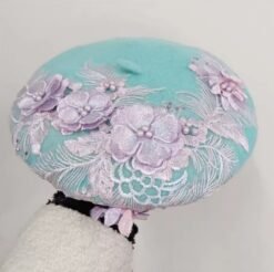 woman holding blue colorful lace beret