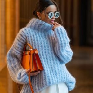 woman wearing blue colorful turtleneck sweater and holding an orange bag