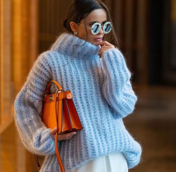 woman wearing blue colorful turtleneck sweater and holding an orange bag