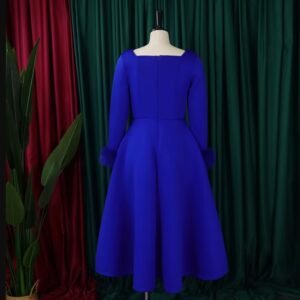 back view of blue long-sleeved colorful dress, green and red curtains in the background