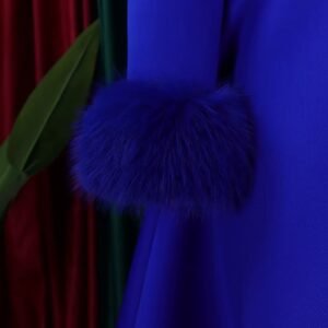 sleeve of blue long-sleeved colorful dress. a palmleaf in the background