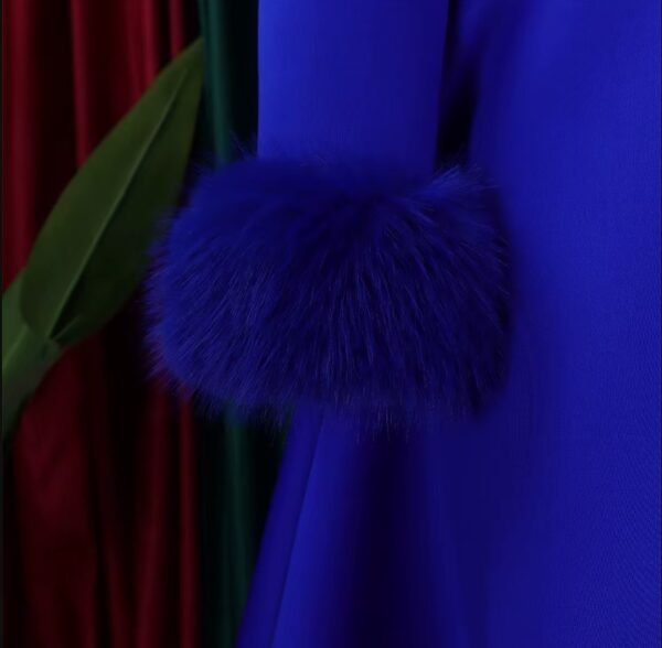 sleeve of blue long-sleeved colorful dress. a palmleaf in the background