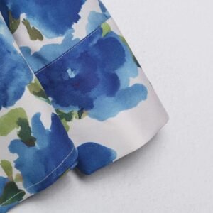 the sleeve of colorful blouse with blue flowers on the white background