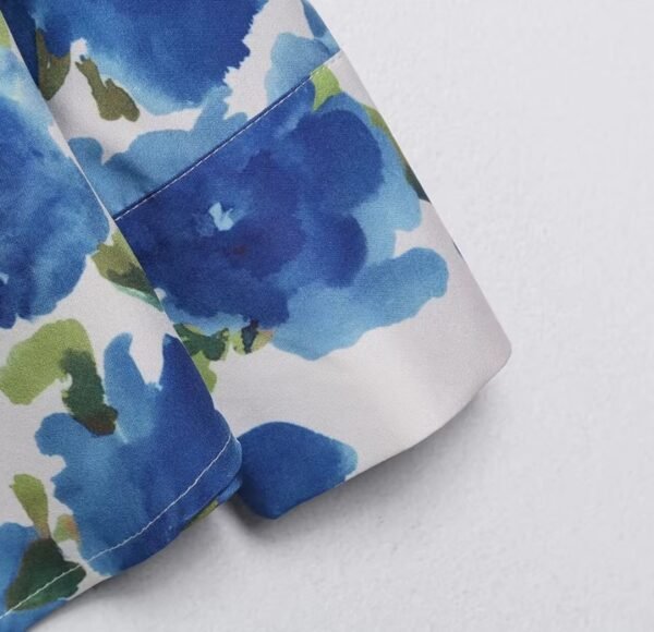 the sleeve of colorful blouse with blue flowers on the white background