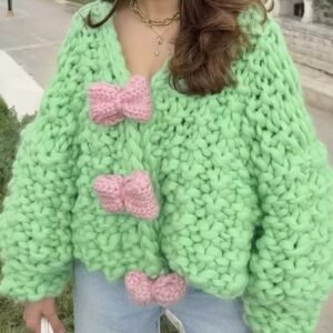 woman with brown hair wearing colorful bowknot cardigan and jeans, the street in the background