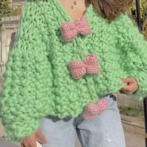 woman with brown hair wearing colorful bowknot cardigan and grabbing its material