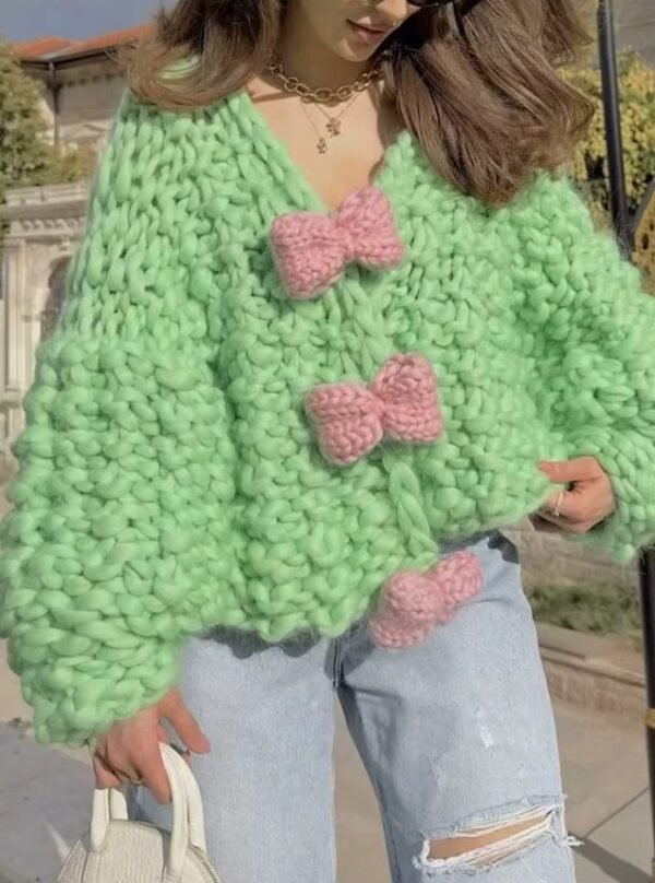 woman with brown hair wearing colorful bowknot cardigan and grabbing its material