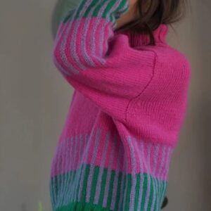 woman wearing colorful color blocking sweater and lifting one hand