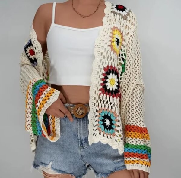 woman wearing colorful crochet cardigan, white top and jeans shorts on the white background