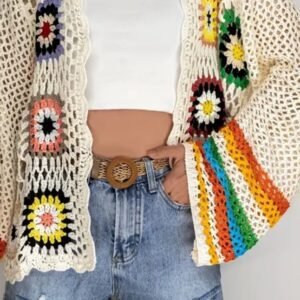 woman wearing colorful crochet cardigan, white top and shorts - she is having one hand in the pocket