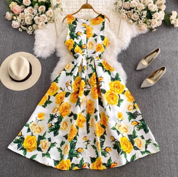 back view of colorful dress with yellow roses on a grey carpet, a beige hat and beige high heels next to it