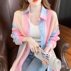 woman wearing colorful gradient blouse over a white top on the brown chair