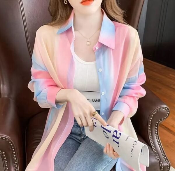 woman wearing colorful gradient blouse over a white top on the brown chair