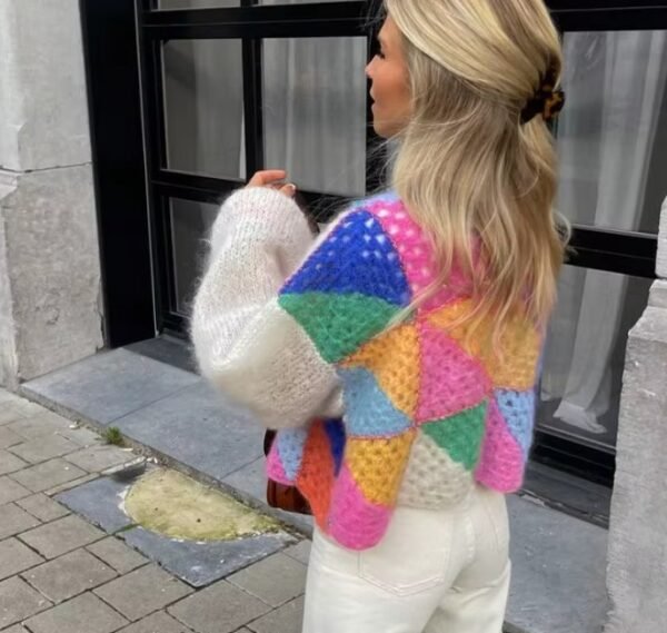 blonde woman turned to her back wearing colorful patchwork cardigan and white jeans