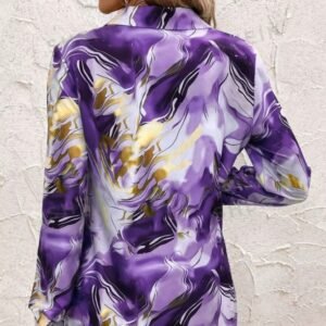 woman turned to her back wearing purple colorful pattern blouse, white wall in the background