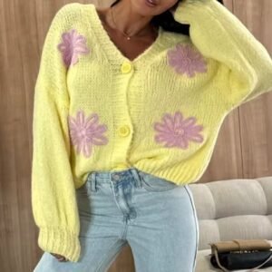 woman wearing colorful spring cardigan and jeans, wooden wall behind her