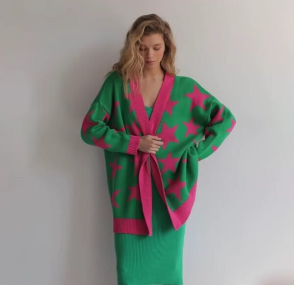 woman wrapping herself up in colorful stars cardigan, white wall in the background