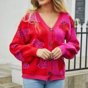 blonde woman wearing colorful strawberry cardigan and jeans