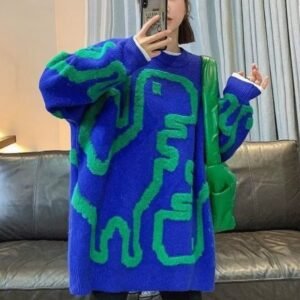 woman wearing colorful streetwear sweater and a green bag, she is holding a phone