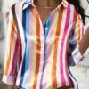 woman wearing colorful striped blouse and white jeans