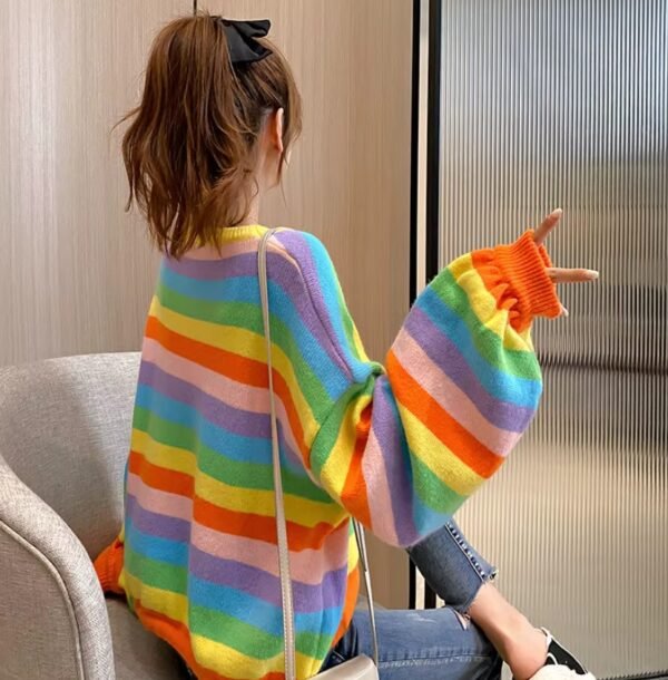 woman turned to her back wearing colorful striped sweater and a black bow in her brown hair