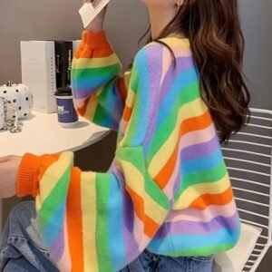 woman turned to her side wearing colorful striped sweater and sitting on a white chair