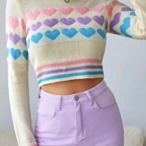 woman wearing colorful sweater with hearts and lavender pencil skirt, white wall behind her