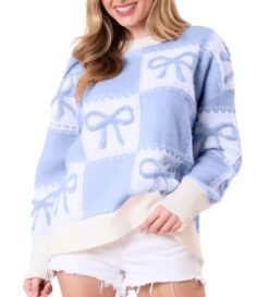 woman wearing blue colorful sweater with ribbons and white shorts