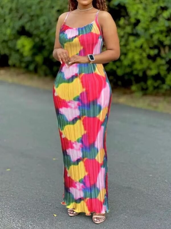 woman wearing colorful tie dye dress, a street and bushes behind her