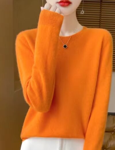 woman wearing orange colorful wool sweater and white pants