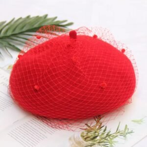 elegant colorful beret on the white table, a green leaves next to it