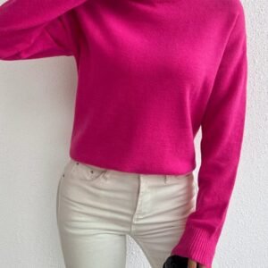 woman wearing fuchsia sweater and white jeans, she is holding a white cup of coffee