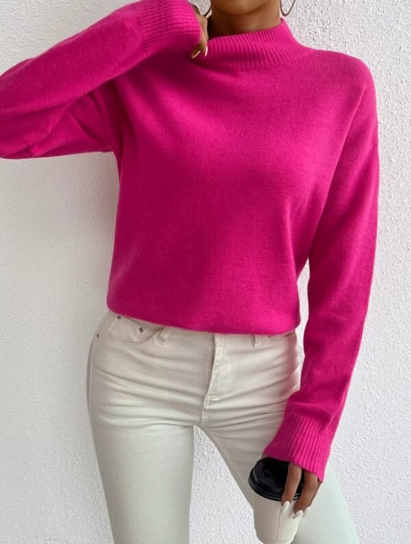 woman wearing fuchsia sweater and white jeans, she is holding a white cup of coffee