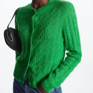 woman wearing green cardigan and carrying a black purse