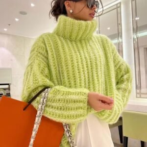 woman wearing green colorful turtleneck sweater and holding an orange bag