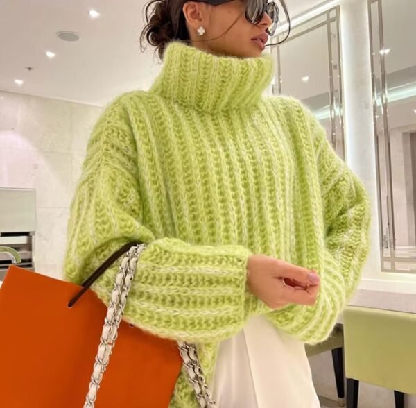 woman wearing green colorful turtleneck sweater and holding an orange bag