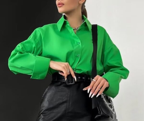 woman wearing green oversized blouse, black pencil skirt and a black purse