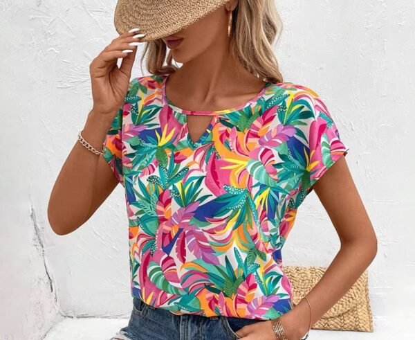 woman posing in Hawaiian colorful blouse and a beige hat, white wall behind her