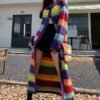 woman wearing long colorful cardigan and black shorts on the street