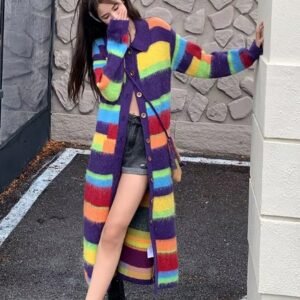 woman wearing long colorful cardigan and shorts, a building behind her