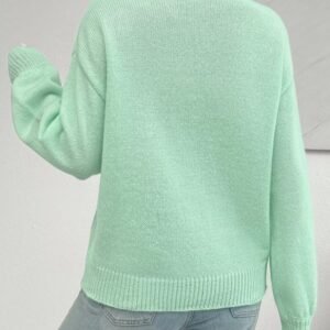 woman turned to her back wearing mint sweater and jeans