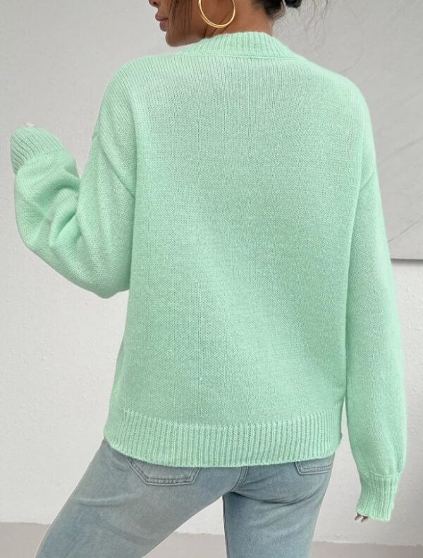 woman turned to her back wearing mint sweater and jeans