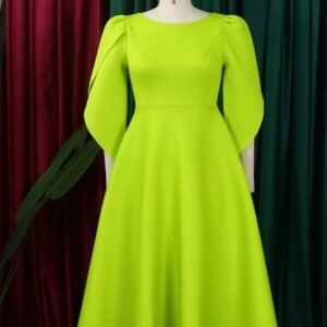 front view of modest colorful dress on a mannequin, red and green curtain in the background