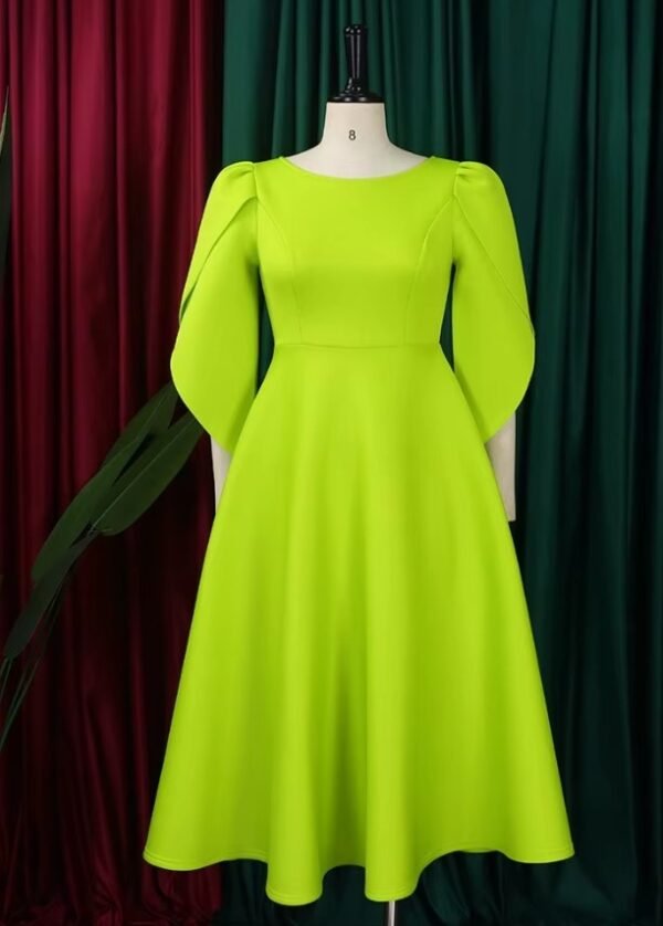 front view of modest colorful dress on a mannequin, red and green curtain in the background