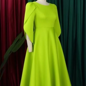 side view of modest colorful dress on a mannequin, red and green curtain in the background