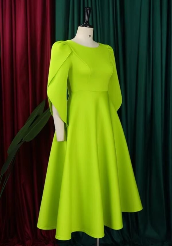 side view of modest colorful dress on a mannequin, red and green curtain in the background