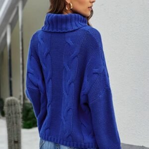 woman with brown hair turned to her back wearing navy blue colorful sweater and jeans